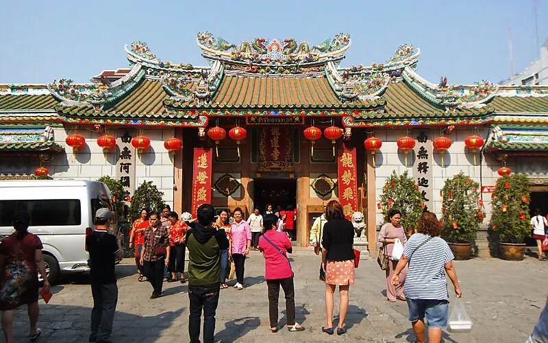 Visitantes fotografam incenso e dragões no templo chinês