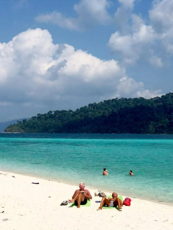 Banhistas relaxam nas areias calmas de Sunset Beach